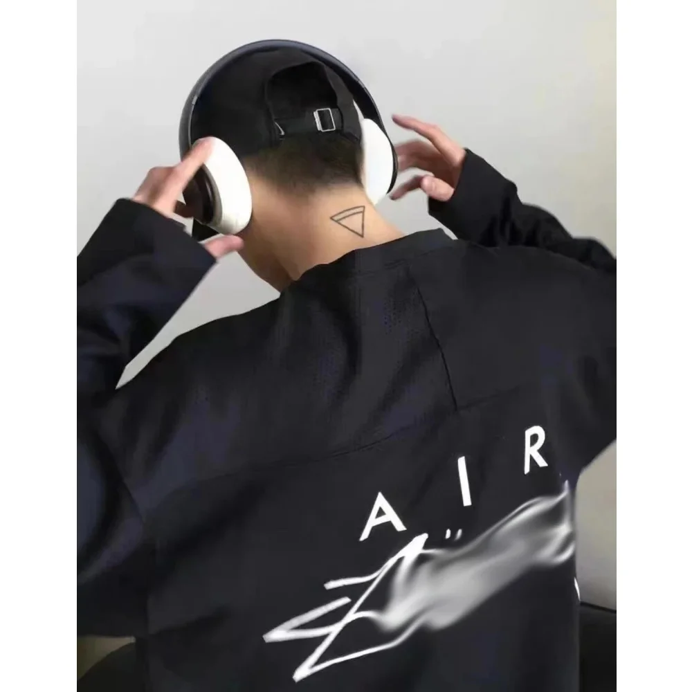 Black long-sleeve top with white AIR text and abstract graphic print
