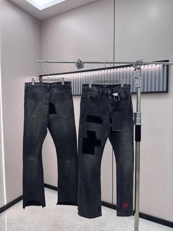 Black distressed denim jeans with velvet patches and frayed hem