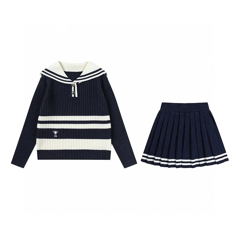 Navy ribbed knit sweater with white stripes and sailor collar paired with pleated navy skirt