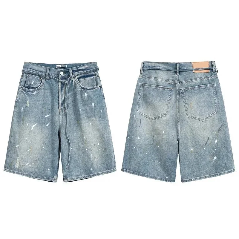 Light wash denim shorts with white and grey paint splatter distressing, wide leg cut