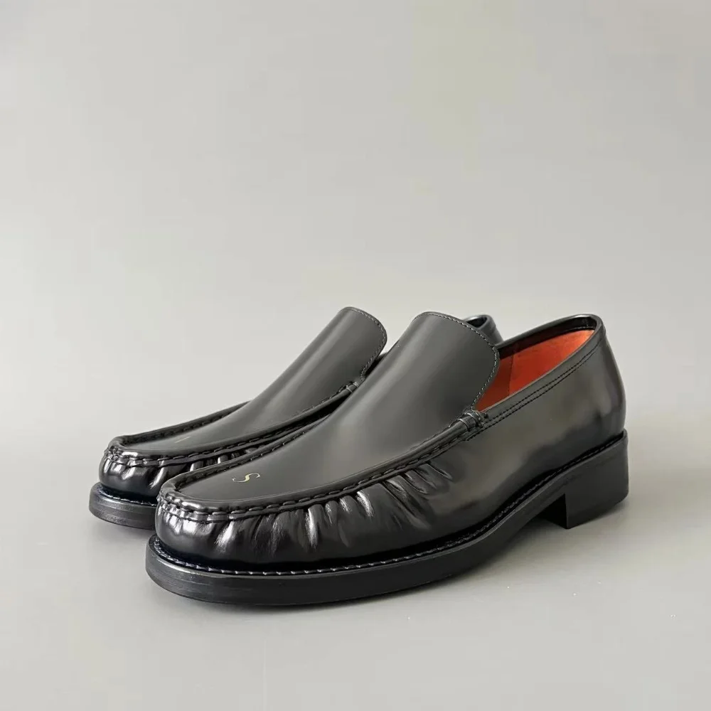 Black patent leather low-top slip-on loafer with stitched moc toe and block heel