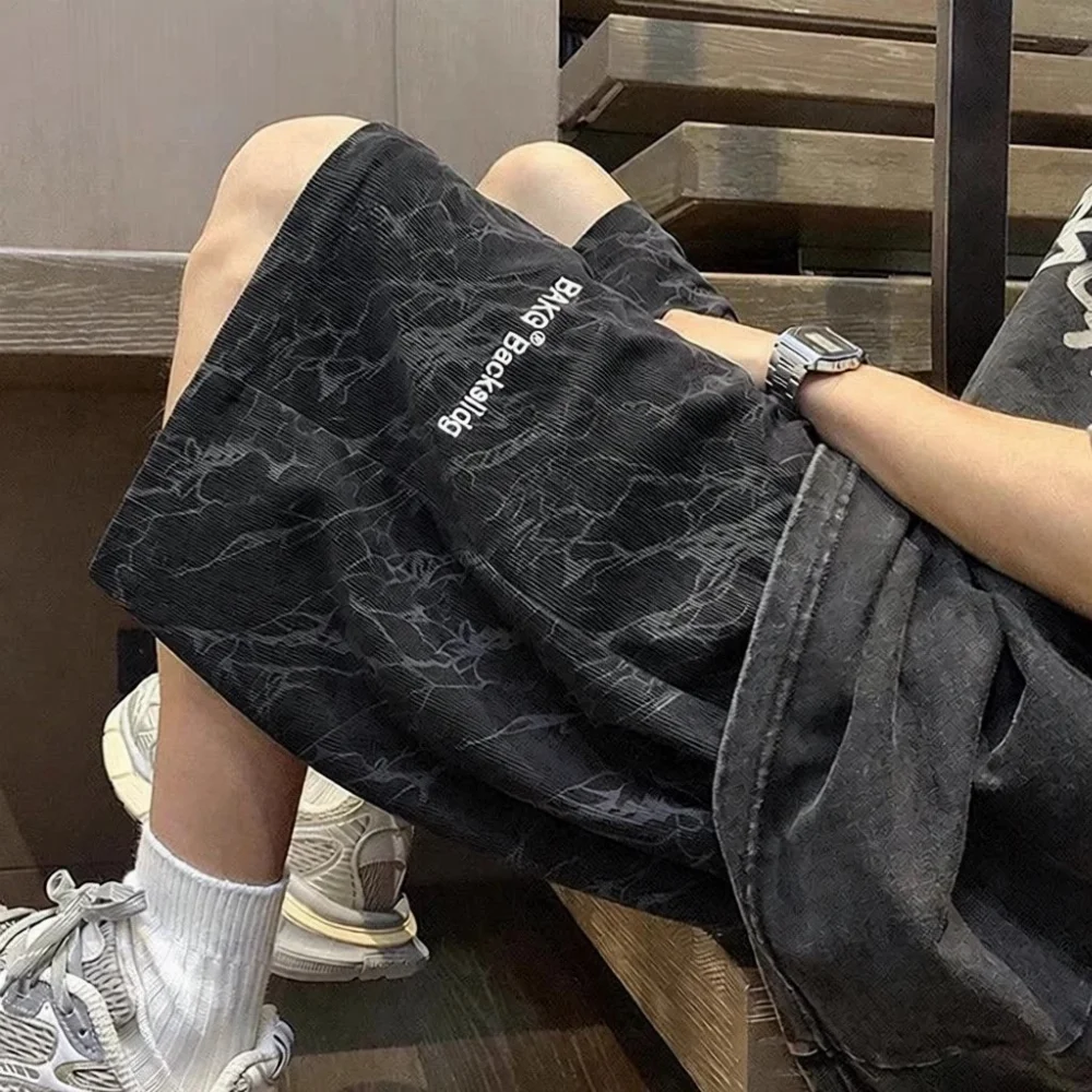 Corduroy shorts with abstract crack pattern and white embroidered text