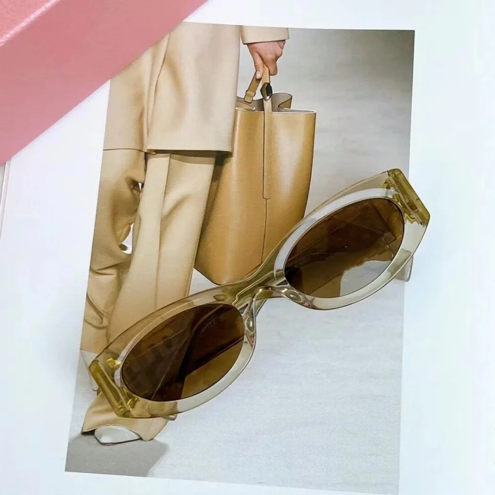 Oval-shaped translucent amber acetate sunglasses with brown gradient lenses