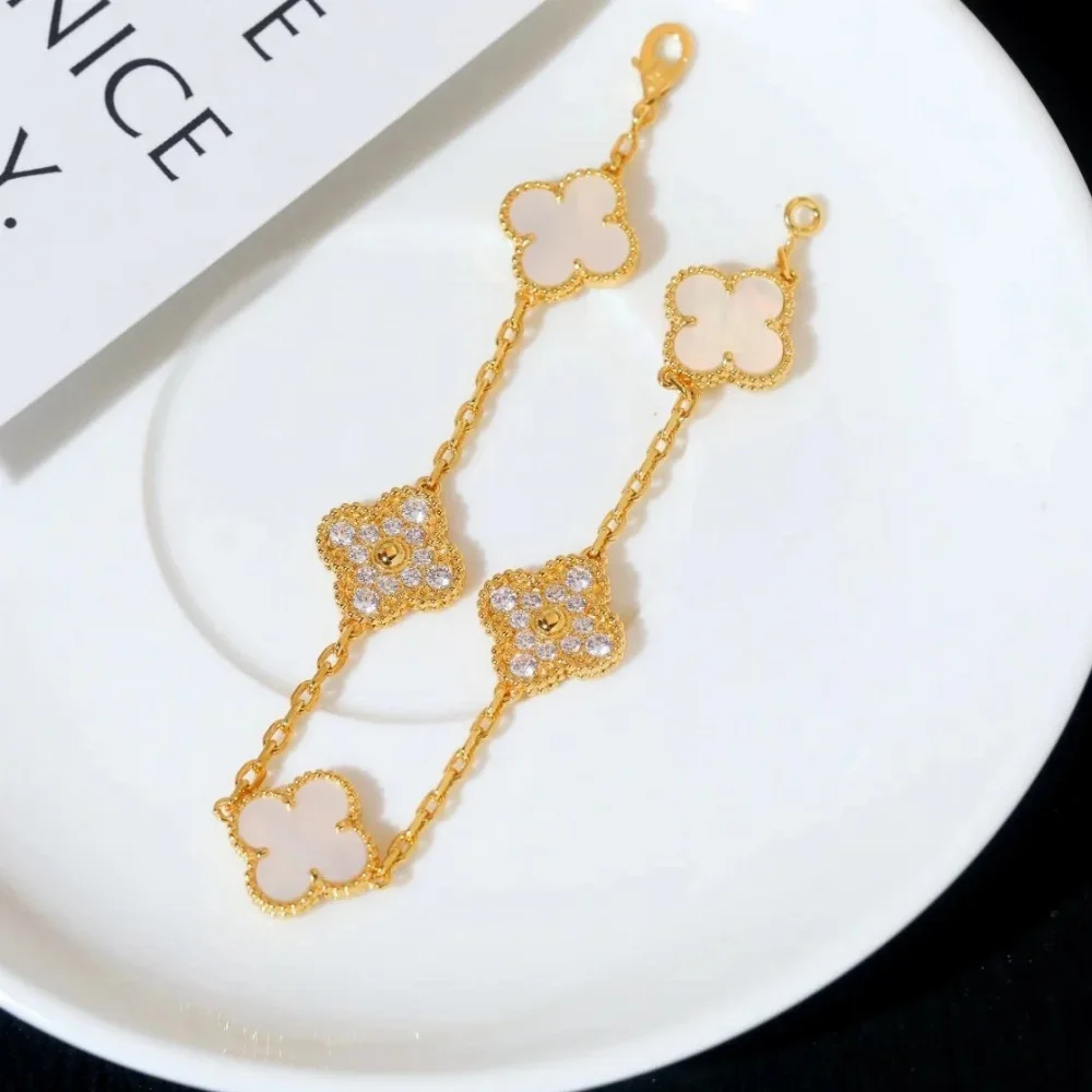 Gold-tone chain bracelet with five clover-shaped motifs, white mother-of-pearl and crystal accents