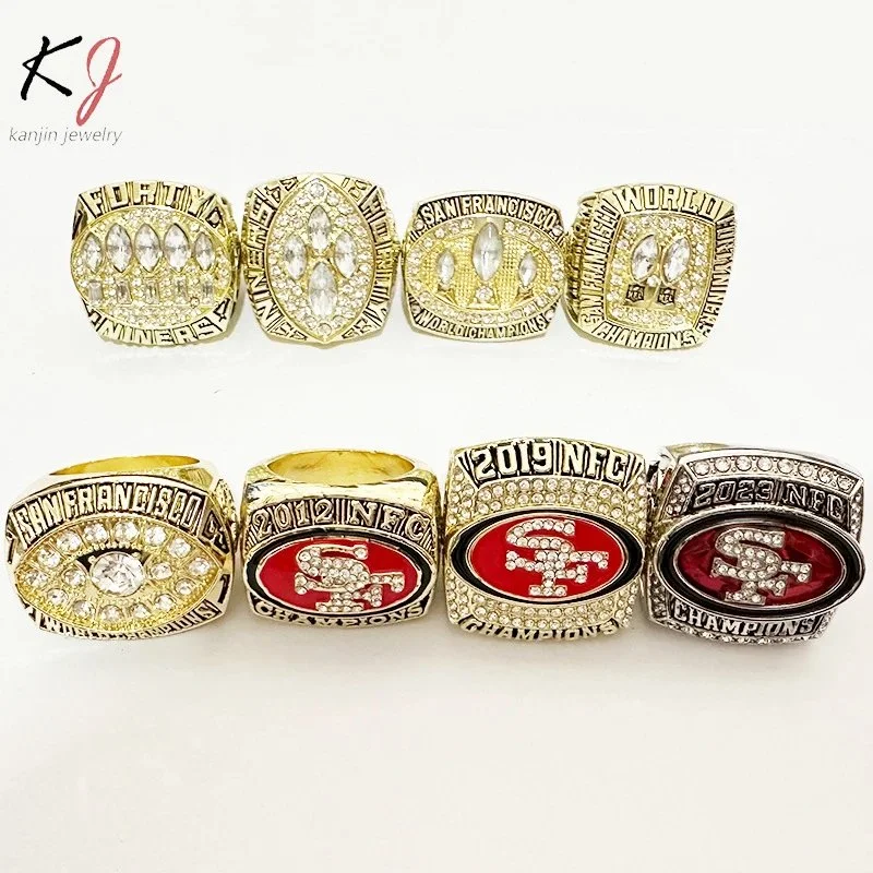 Gold-tone championship rings with red SF logo and crystal accents in wooden display box