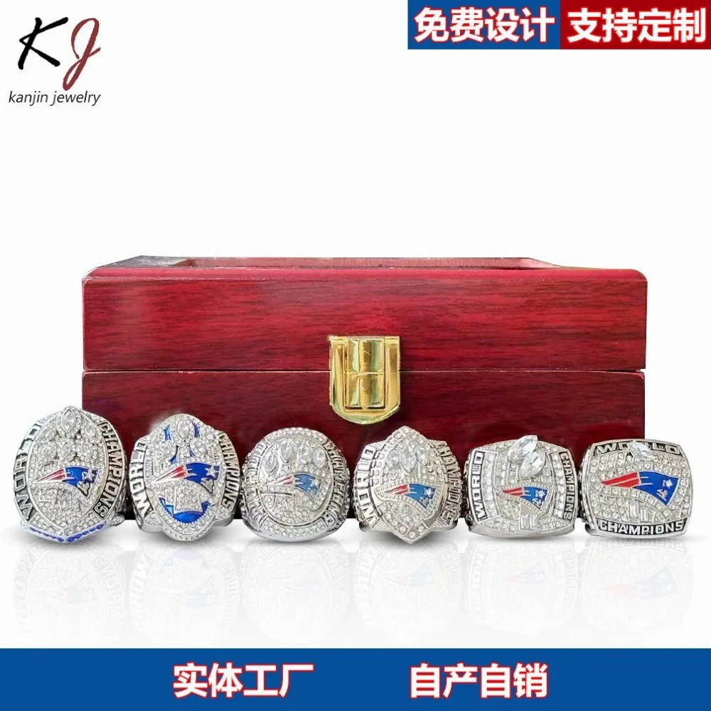 Silver-tone championship rings with blue red white enamel logos set in wooden box