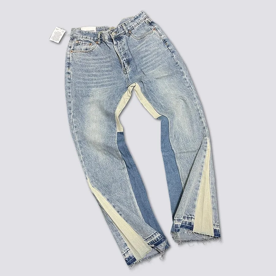 Light wash denim pants with contrast beige paneling and frayed hem