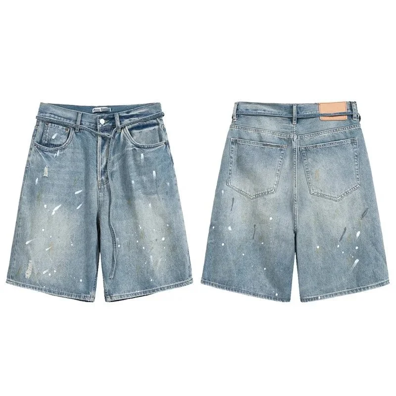 Light wash denim shorts with white paint splatter distressing and frayed details
