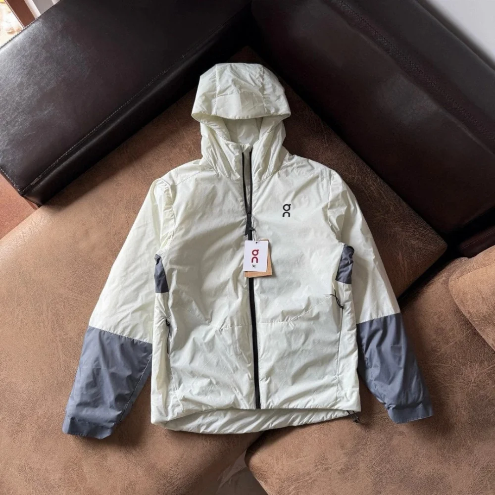 On lightweight off-white hooded jacket with gray sleeve panels and black zipper