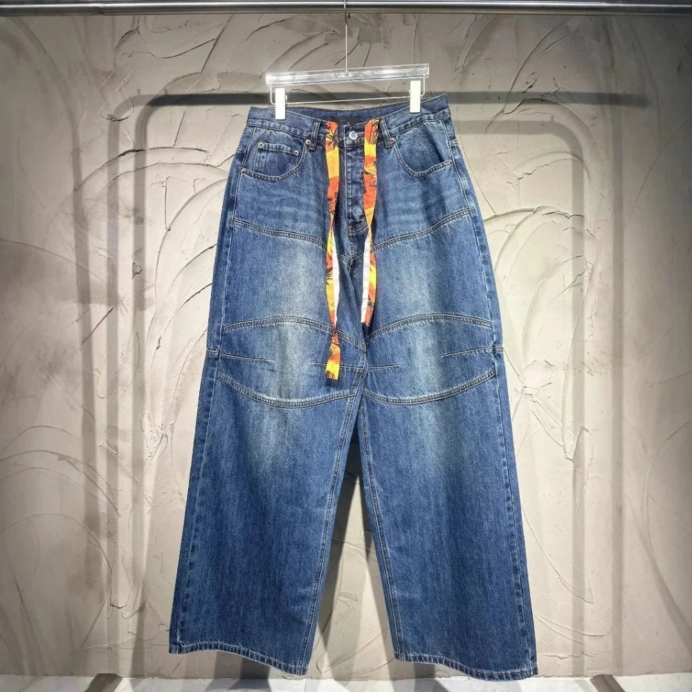 wide-leg blue denim pants with panelled construction and printed fabric waist tie